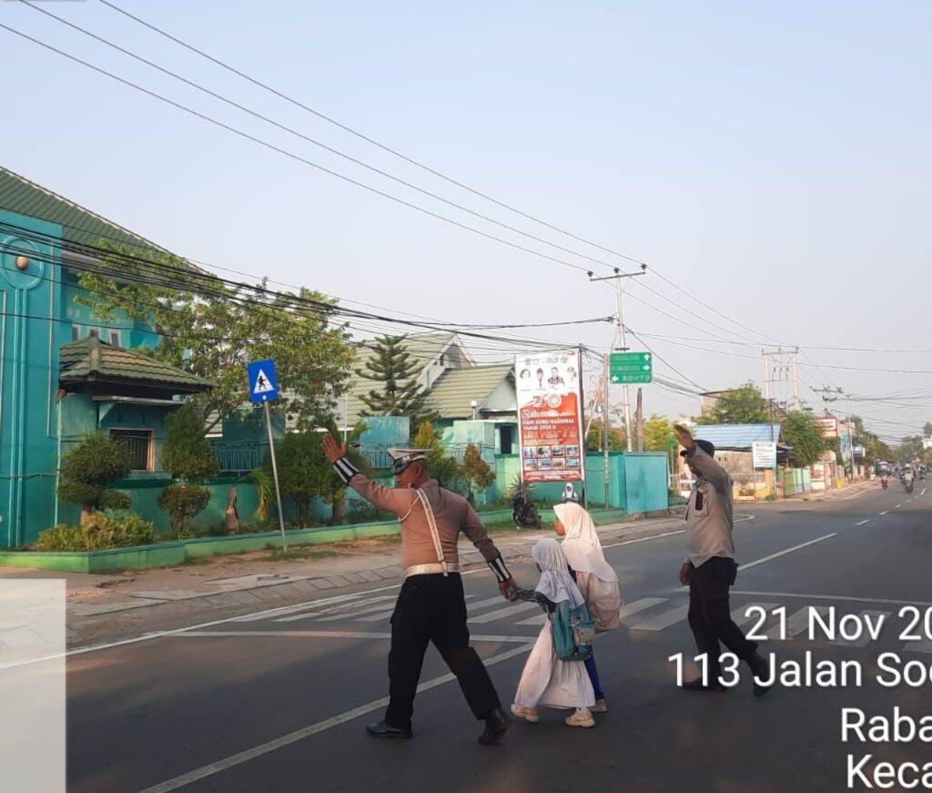 Satlantas Polres Bima Kota Bantu Anak Sekolah Menyeberang Jalan dalam Gatur Pagi